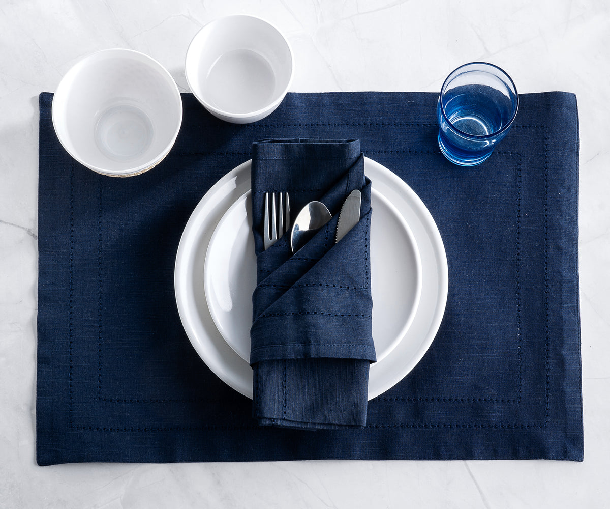 Table setting featuring blue double hemstitch cloth napkins and silverware