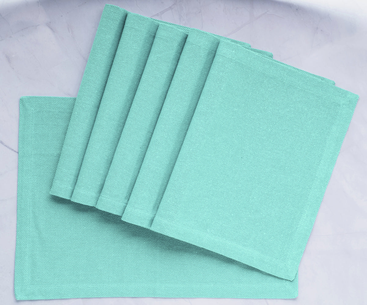 Transform your dining table with green fabric placemats, providing charm and protection for a delightful and stylish mealtime upgrade.