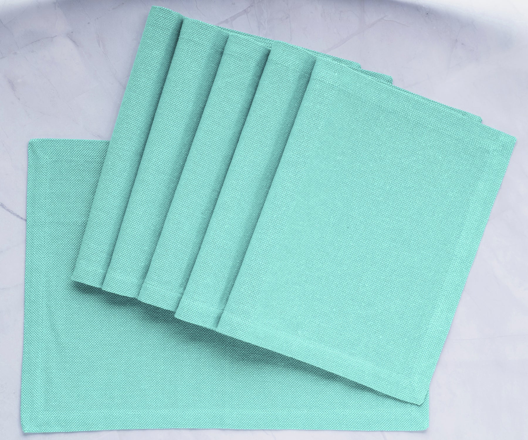 Transform your dining table with green fabric placemats, providing charm and protection for a delightful and stylish mealtime upgrade.