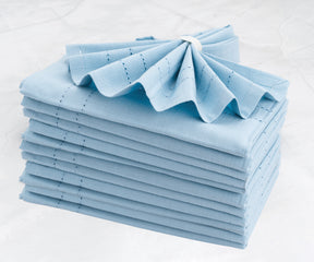 Neatly arranged stack of blue cloth napkins on a clean background