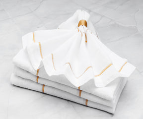 Elevate your table settings with dinner napkins available in both cloth and folding styles, offering a choice between white and black options.Elegant Gold Cloth Napkins Spread on a Festive Table