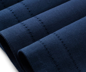Folded rectangular placemats of size 13×18", hem stitched navy blue woven placemats are arranged
