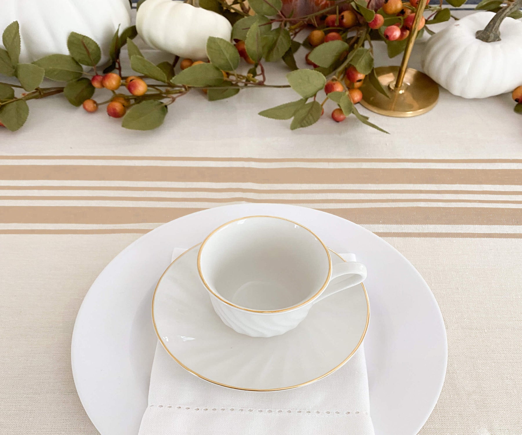 The 60-inch round beige tablecloth combines practicality and style, creating a welcoming and visually appealing dining environment.