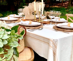 Outdoor dinner party table set up with a farmhouse tablecloth