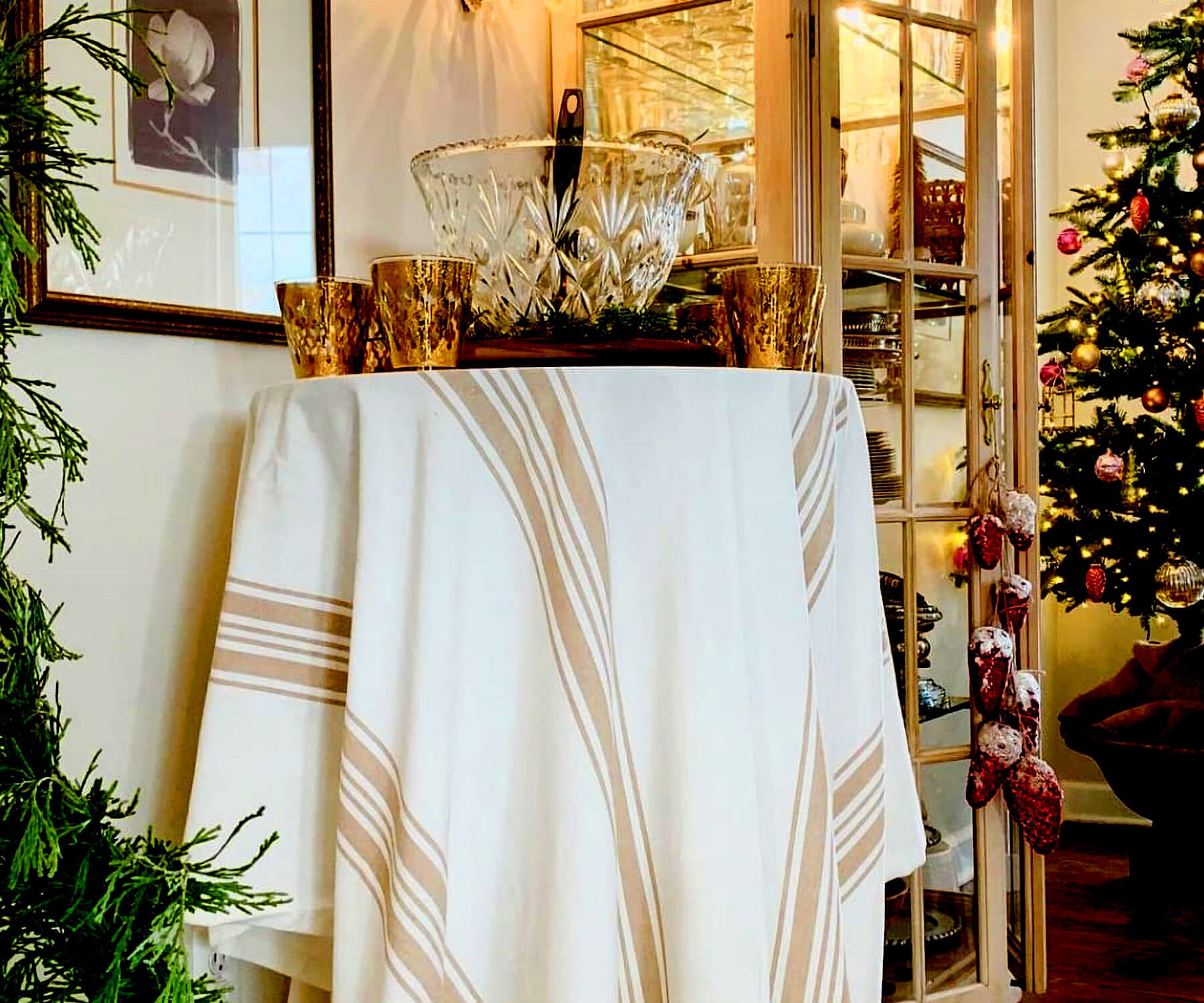 Round outdoor tablecloth displayed on a table with Christmas decor