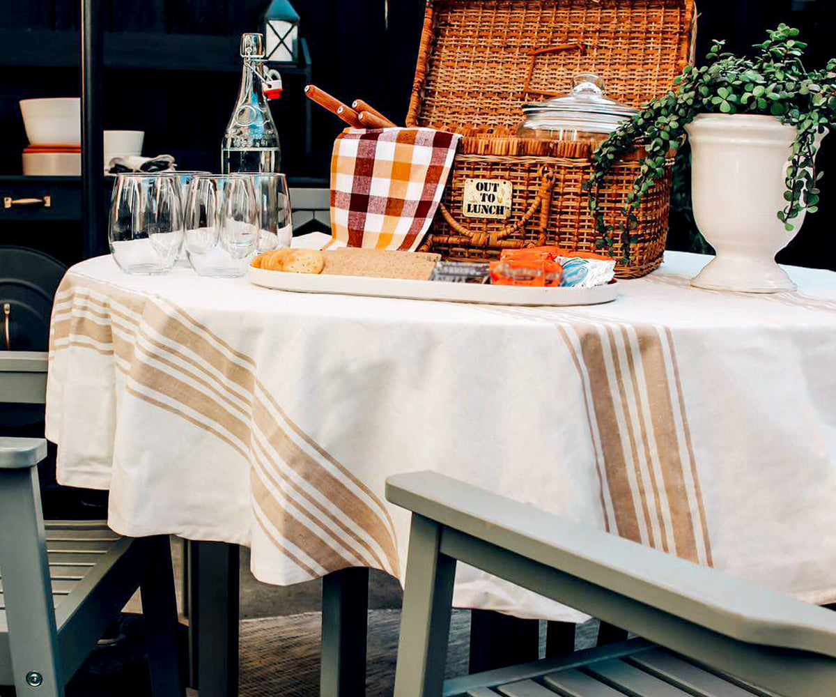 Dining table set up with a round outdoor tablecloth and a variety of drinks