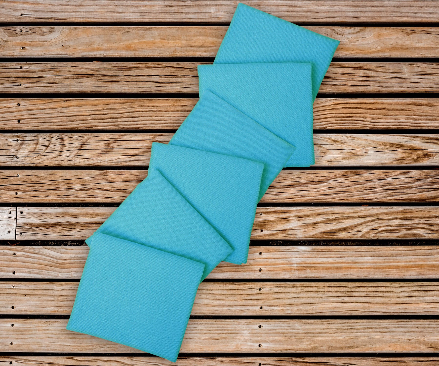 Napkins cloth washable napkins with 1" borders are arranged alternately on the wood