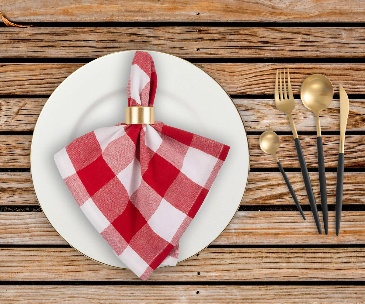 Folded diner napkins with 2" checked pattern and red and white shaded cloth napkins are placed on plate and with spoons