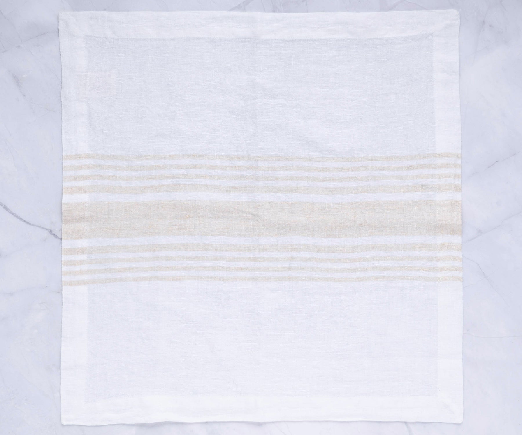 Beige striped linen dinner napkin on a marble background