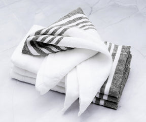 Stack of linen dinner napkins featuring white and gray stripes