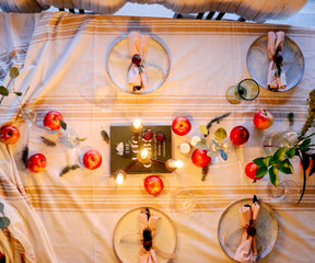 Dinner table set with Farmhouse tablecloth, apples, and candles