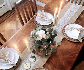 Table setting with white plates, candles, and a blue and white striped bistro napkin