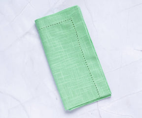 linen napkins green, cloth napkins set of 6 with borders are folded and placed on the white floor.