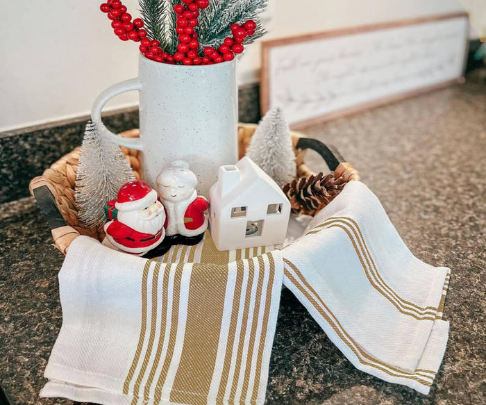 Set of 4 beige striped cotton kitchen towels neatly folded on countertop
