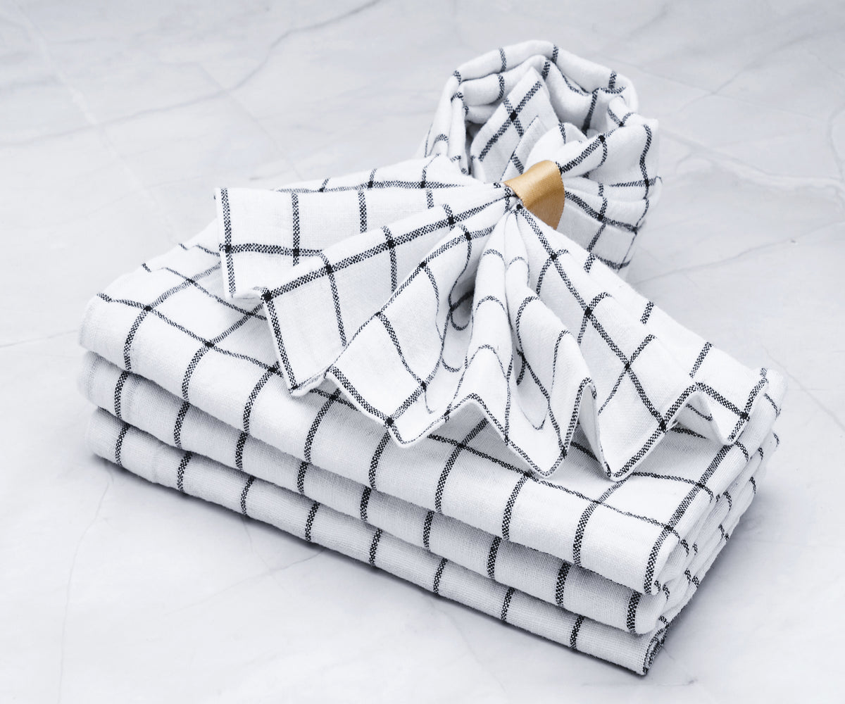 A bulk quantity of white linen napkins neatly stacked.