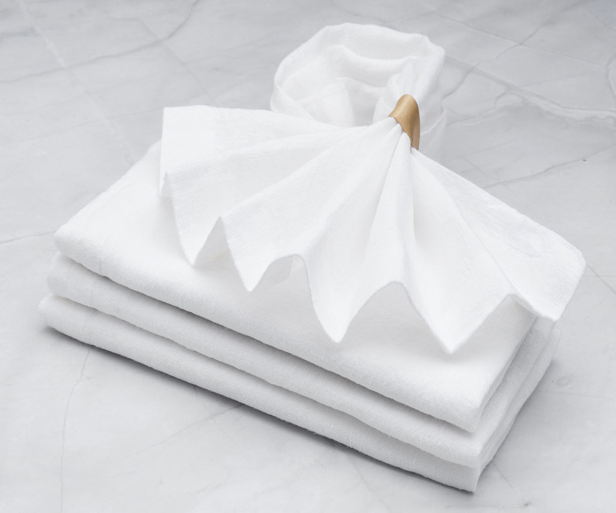 White cloth napkins elegantly crumpled on a dining table setting