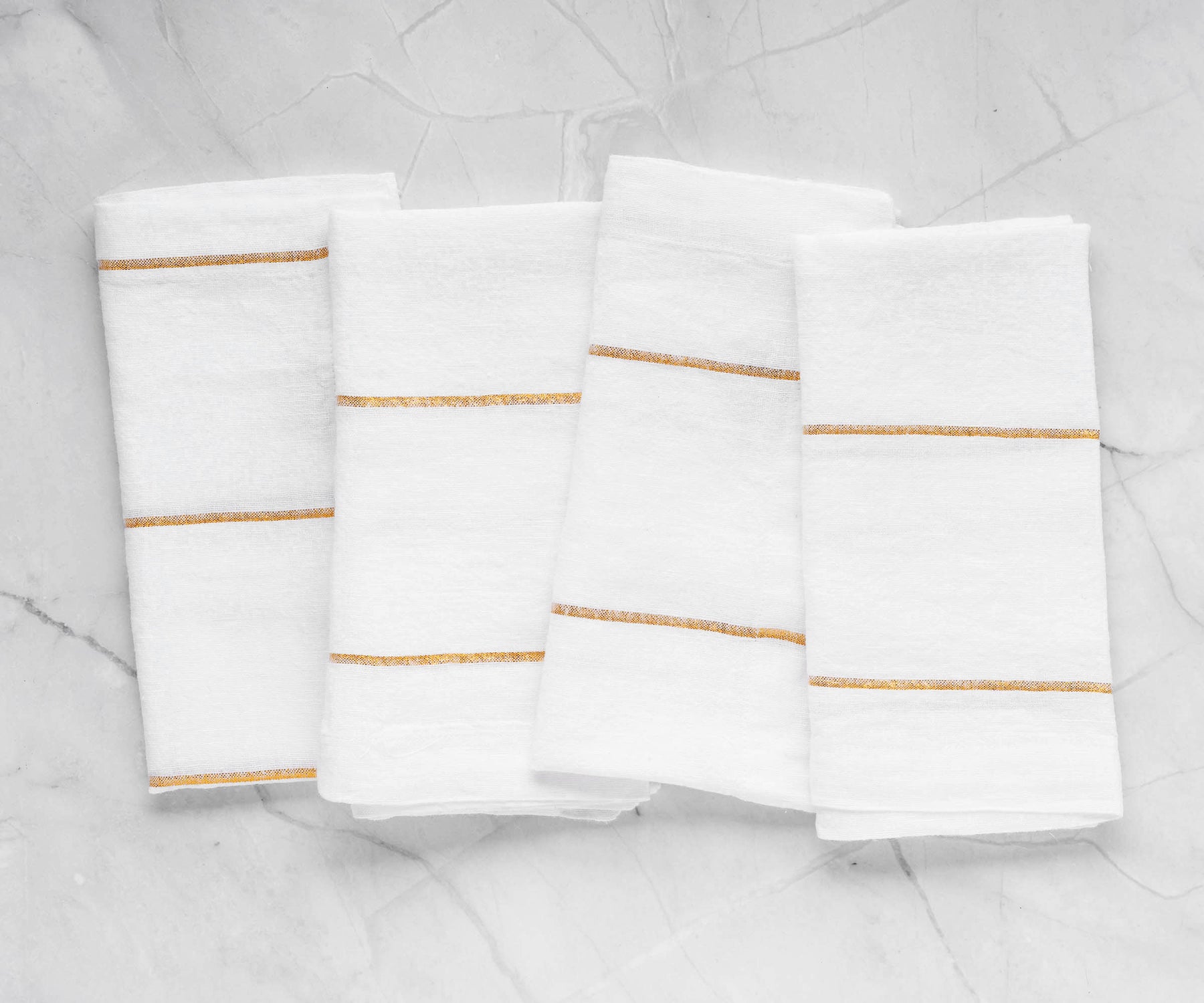 Transform your table settings with a selection of dinner napkins, encompassing cloth and folding variations, in white and black alternatives.Detailed Shot of Gold Linen Napkins with a Charming Texture
