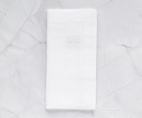 White linen napkin resting on a marble surface with soft lighting