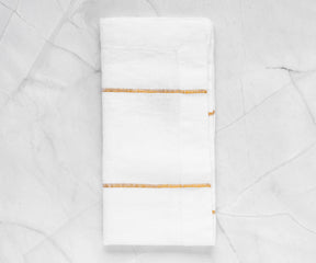 Enhance your table presentation with dinner napkins, offering cloth and folding choices in white and black, perfect for a stylish dining experience.Display of Luxurious White and Gold Dinner Napkins Wrapped Around Silverware