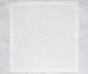 Single white cotton napkin laid out on a marble surface