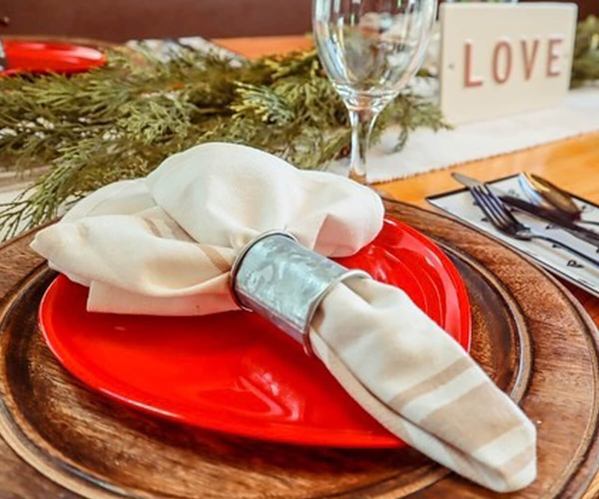 White Napkins-Cotton napkins with Beige and cream Reusable napkins cloth  are folded with grass & placed on the plate on the table.