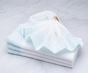 A bulk pack of cream cloth napkins for restaurant use