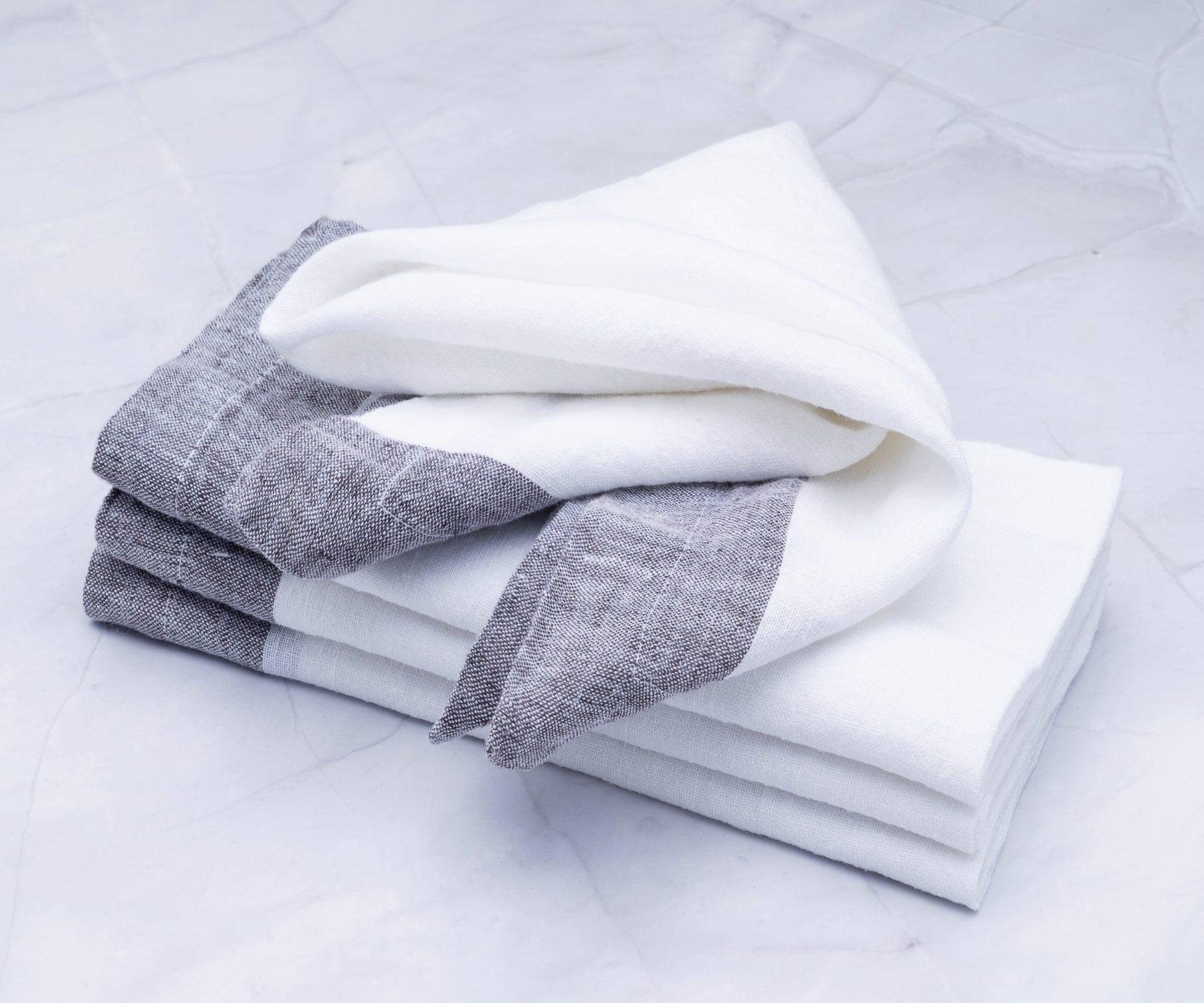 A collection of white cloth napkins for a formal dining setup